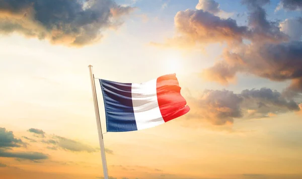 France waving flag in beautiful sky with clouds and sun