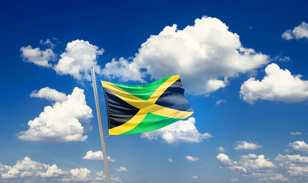 Jamaica waving flag in beautiful sky with clouds