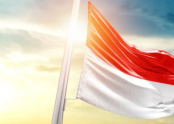 Indonesia flag against sky with sun