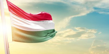 Macaristan bayrağı bulutlu ve güneşli gökyüzüne karşı