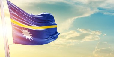 Nauru bayrağı bulutlu ve güneşli gökyüzüne karşı