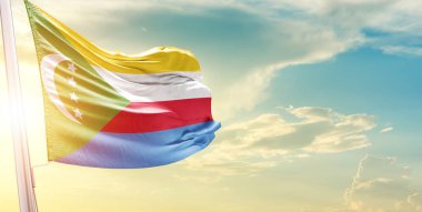 Komorolar bulutlu ve güneşli gökyüzünde bayrak sallıyor