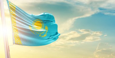 Kazakistan bayrağı bulutlu ve güneşli gökyüzüne karşı