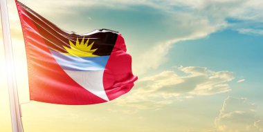 Antigua ve Barbuda bayrağı bulutlara ve güneşe karşı