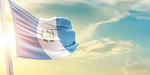 Guatemala bayrağı bulutlara ve güneşe karşı