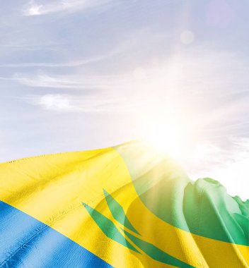 Saint Vincent ve Grenadinler bulutlu mavi gökyüzüne bayrak sallıyor