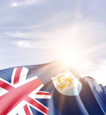 Anguilla bayrağı bulutlu ve güneşli mavi gökyüzüne karşı