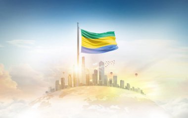 Gabon bayrağı şehir manzarasına karşı dalgalanıyor