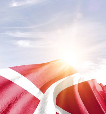 Danimarka bayrağı güneşle gökyüzüne karşı dalgalanıyor
