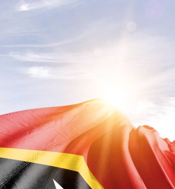 Doğu Timor bayrağı güneşle gökyüzüne karşı dalgalanıyor