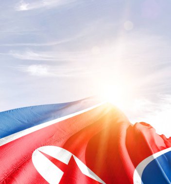 Kuzey Kore bayrağı güneşle gökyüzüne karşı dalgalanıyor