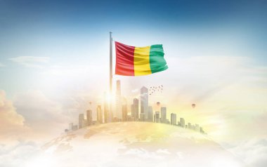 Şehir manzarasının üzerinde Gine bayrağı simgesi 