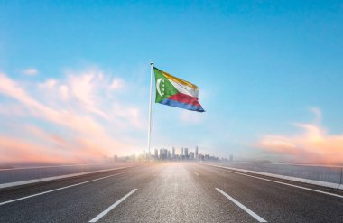 flag of Comoros on the highway with cityscape view