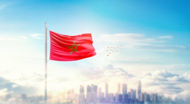 Güzel bina siluetinde dalgalanan Fas ulusal bayrağı.