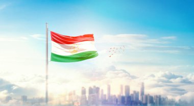 Güzel bina siluetinde dalgalanan Tacikistan ulusal bayrağı.