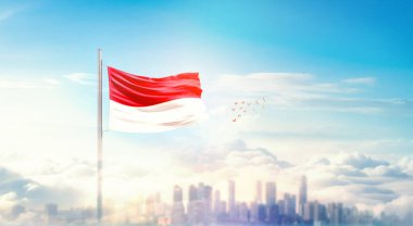 Güzel bina siluetinde sallanan Monako ulusal bayrağı 