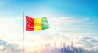 Güzel bina siluetinde sallanan Ulusal Gine bayrağı 