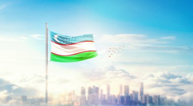 Özbekistan ulusal bayrağı güzel bina siluetinde dalgalanıyor.