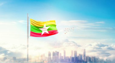Myanmar ulusal bayrağı güzel bina siluetinde dalgalanıyor. 