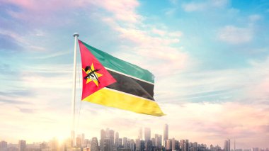 Mozambik bayrağı mavi gökyüzü arka planında şehir manzarası ile dalgalanıyor 