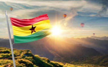 Gana sıcak hava balonlarıyla gün batımında bayrak sallıyor.