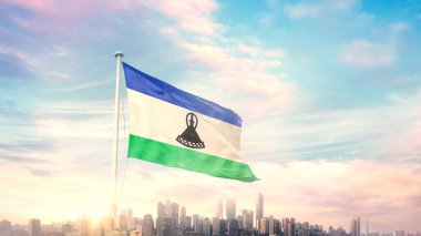 Mavi gökyüzü arka planında şehir manzaralı Lesotho bayrağı dalgalanıyor 