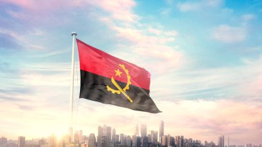 Angola bayrağı mavi gökyüzü arka planında şehir manzarası ile dalgalanıyor 