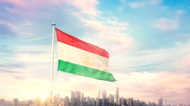 Tacikistan bayrağı mavi gökyüzü arka planında şehir manzarası ile dalgalanıyor 