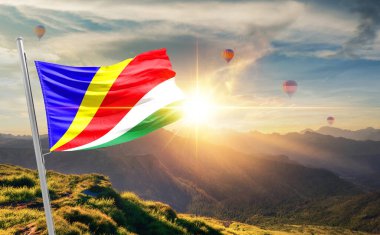 Seyşeller gün batımında sıcak hava balonlarıyla dağlarda bayrak sallıyor.