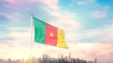 Şehir manzaralı mavi gökyüzü arka planında dalgalanan kamerun bayrağı 