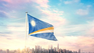 Marshall Adaları bayrağı mavi gökyüzü arka planında şehir manzarası ile dalgalanıyor 