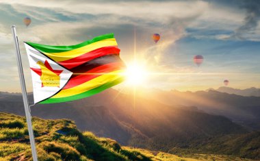 Zimbabwe gün batımında sıcak hava balonlarıyla dağlarda bayrak sallıyor.