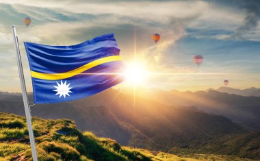 Nauru gün batımında sıcak hava balonlarıyla dağlarda bayrak sallıyor.