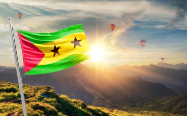 Sao Tome ve Principe gün batımında bayrak sallıyor. Arka planda sıcak hava balonları var.