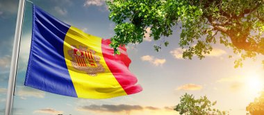 Andorra ulusal bayrağı dalgalanıyor ağacın yanındaki bulutlara