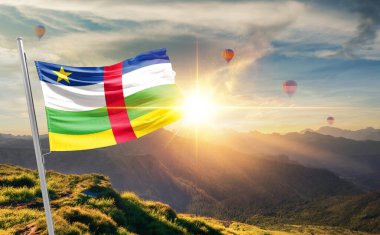 Orta Afrika Cumhuriyeti günbatımında arka planda sıcak hava balonlarıyla bayrak sallıyor. 