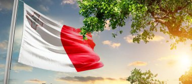 güneşli mavi gökyüzü ve Malta bayrağı