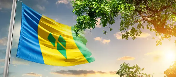 Aziz Vincent ve Grenadinler gün batımına karşı bayrak sallıyorlar.