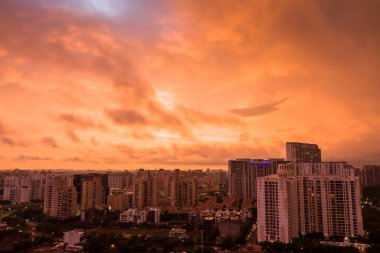 Gurgaon, Haryana, Hindistan 'ın renkli günbatımı. Modern mimari, ticari, lüks apartman binaları olan Gurugram kentsel gökyüzü manzarası. Delhi NCR bulutlu güzel şehir manzarası, şehir ışıkları..
