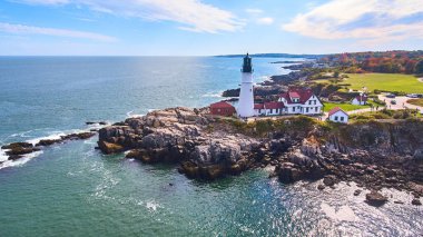 Image of Stunning lighthouse on rocky cliffs in Maine from aerial view clipart