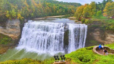 Renkli yaprakları ve Vista 'dan hayranlık duyan turistlerle nehirde akan dev şelalenin görüntüsü