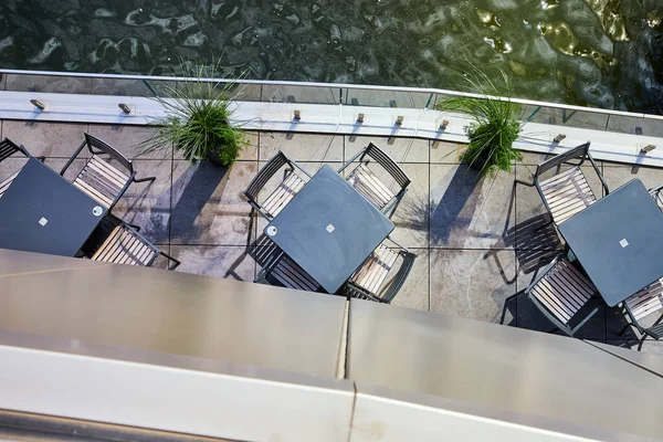 Image of Looking down on dining patio tables next to water