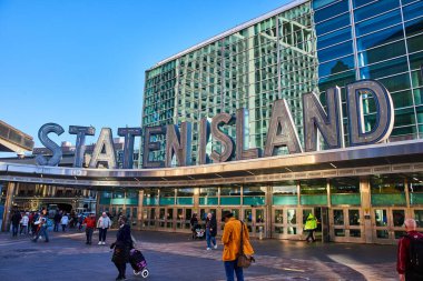 Staten Island 'ın New York' ta turistlerle dolu bir feribot binasına açılan devasa giriş tabelası.