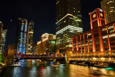 Bütün gökdelenlerde ışıkları olan gece Chicago gemi kanallarının görüntüsü