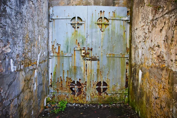 Image of Old mine entrance with cement walls and huge steel door rusting
