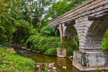 Tren yolu köprüsünden geçen büyük taştan kemerlerle Nehir 'in görüntüsü