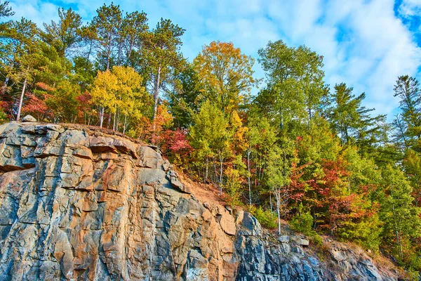 Image of Cliff edge with rows of colorful fall leaves on top