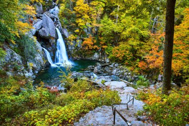 Image of Stairs leading down to beautiful waterfall in fall forest of New York clipart