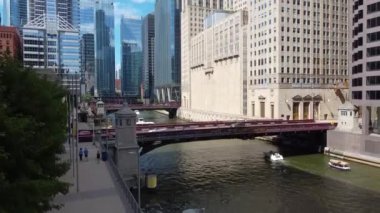 Havadan Şikago nehir kanalına kadar birçok köprüsü ve yansıtıcı cam gökdelenleri olan bir video.