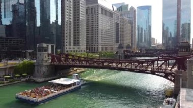 Gökdelenlerle çevrili Chicago gemi kanalı boyunca gemiyle köprüden aşağıya inen Aerial 'ın videosu.